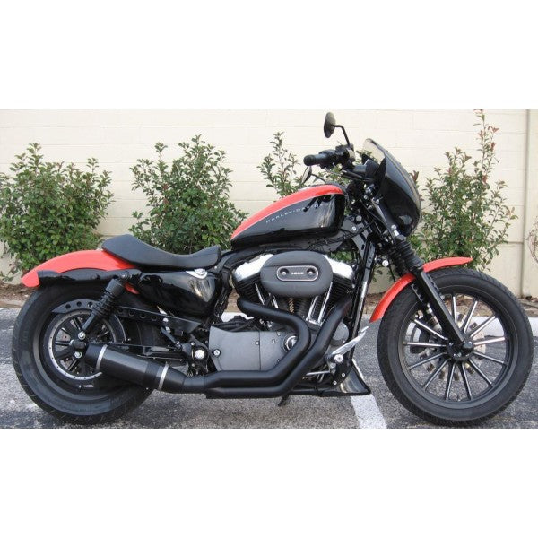 Black and red motorcycle parked on a street with bushes in the background