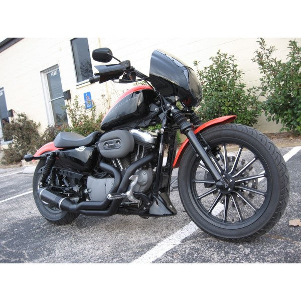 Motorcycle parked on a street with buildings and trees in the background