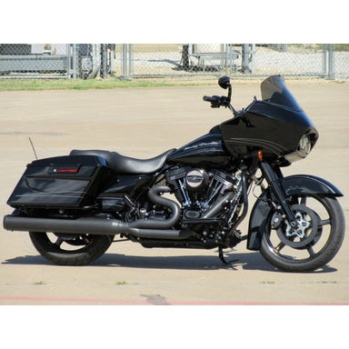 Black motorcycle parked on a paved surface with a chain-link fence in the background.