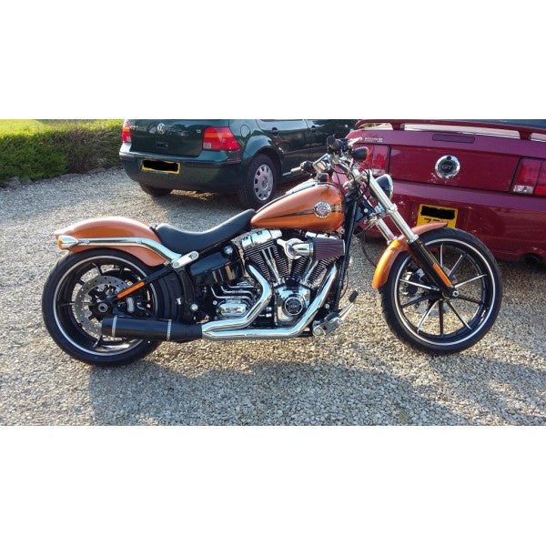 Motorcycle parked on a gravel surface with cars in the background