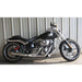 Black motorcycle parked on a concrete surface with a corrugated metal wall in the background
