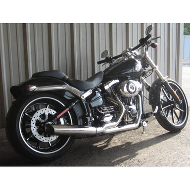 Black motorcycle parked on a concrete surface with a metal wall in the background