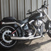 Black motorcycle parked against a metallic wall