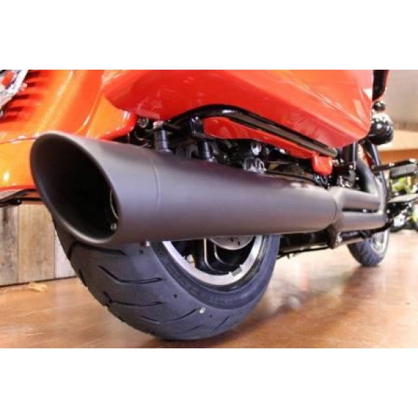Close-up of a motorcycle exhaust on a wooden floor