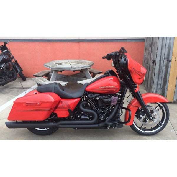Red motorcycle parked on a concrete surface with a wooden wall in the background