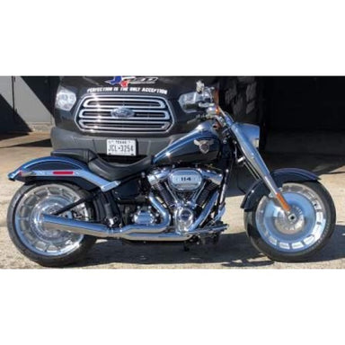 Motorcycle parked in front of a black Ford truck with a Texas license plate.