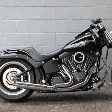 Black motorcycle parked against a gray brick wall