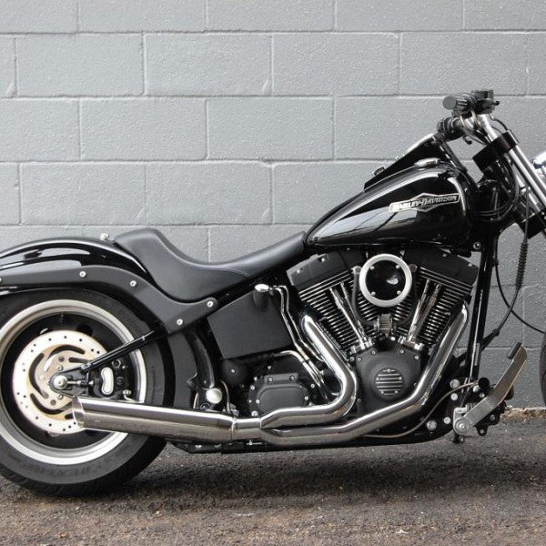 Black motorcycle parked against a gray brick wall
