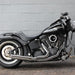 Black motorcycle parked against a gray brick wall