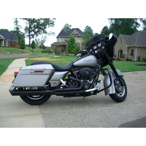 Harley Davidson motorcycle parked on a driveway with houses in the background
