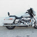 Silver motorcycle parked on a concrete surface with a light gray wall in the background