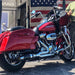 Red motorcycle with chrome details parked in front of a building with an American flag.