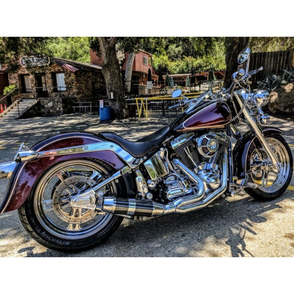 Maroon motorcycle with chrome details parked on a street.