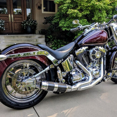 Maroon motorcycle parked on a driveway with a house in the background