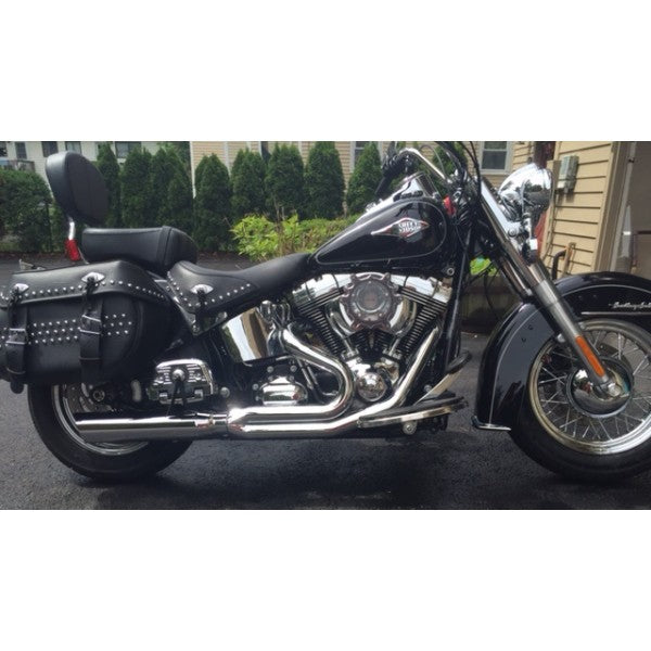Black motorcycle parked on a driveway with a house and trees in the background