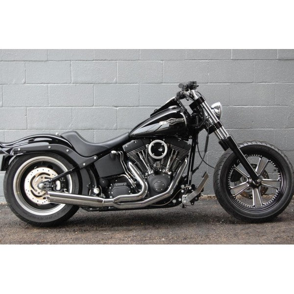 Black motorcycle parked against a gray brick wall