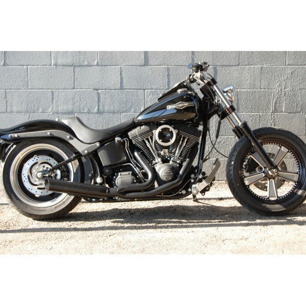 Black motorcycle parked against a gray brick wall.