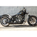 Black motorcycle parked against a gray brick wall.