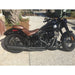 Black motorcycle with brown seat parked on a concrete surface.