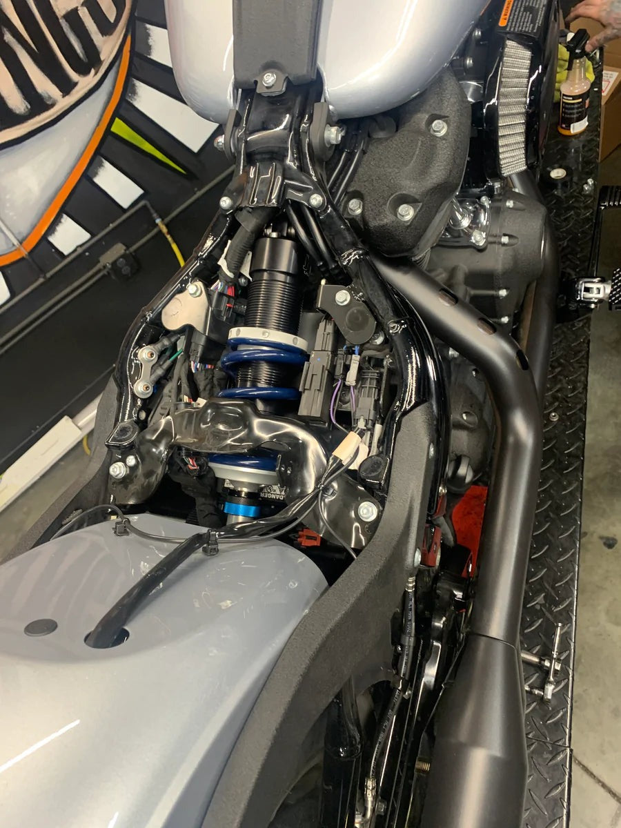 Close-up of a motorcycle engine and suspension system.