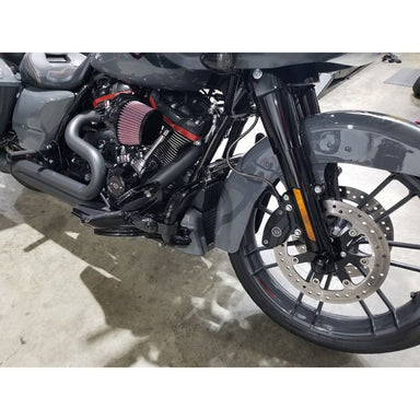 Close-up of a motorcycle's engine and front wheel on a concrete surface