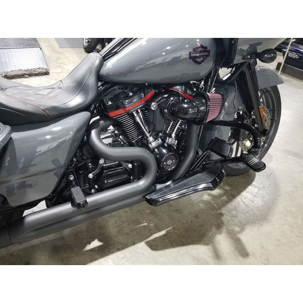 Gray motorcycle with visible engine and exhaust on a concrete floor.