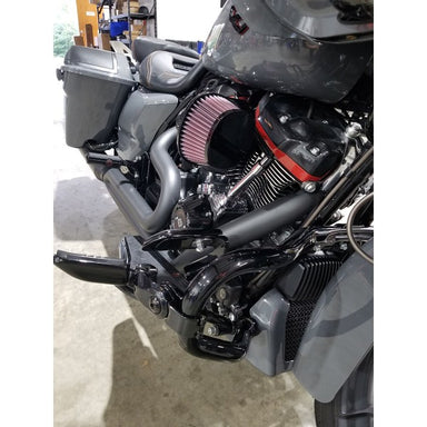 Close-up of a motorcycle engine with a red air filter in a garage setting