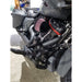 Close-up of a motorcycle engine with a red air filter in a garage setting