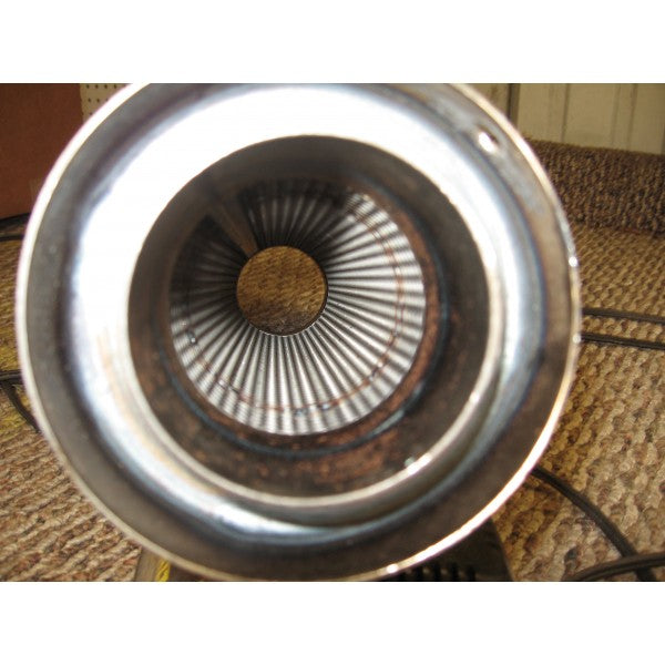 Close-up of a metal object with a textured surface on a wooden floor.