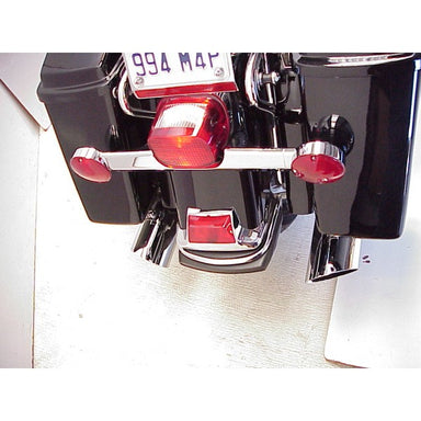Close-up of a motorcycle's exhaust system with red tail lights on a white background