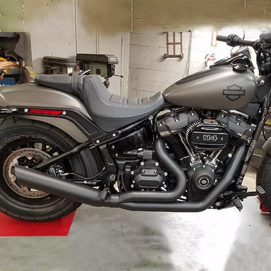Gray motorcycle parked inside a garage with tools and equipment in the background.