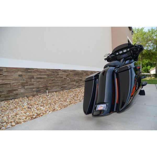 Motorcycle with large saddlebags parked on a driveway.
