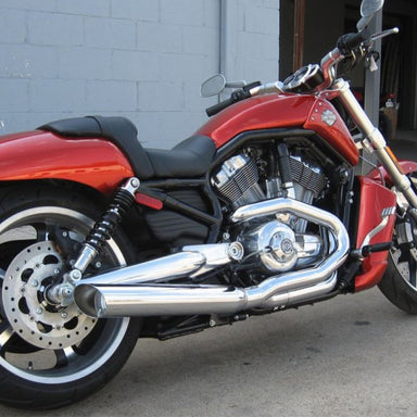 Red motorcycle with chrome details parked against a gray wall.