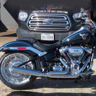 Motorcycle in front of a Ford vehicle with visible license plate